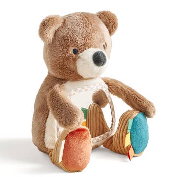 Plush teddy bear with colorful wheels on a white background