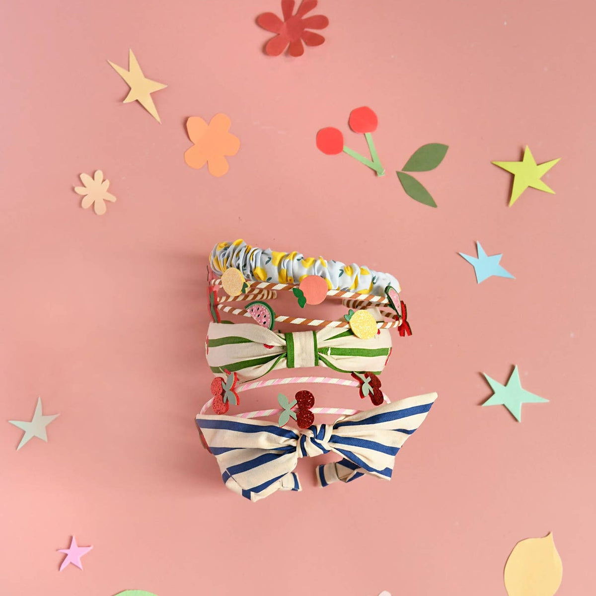 Set of colorful hairbands on a pink background with decorative elements