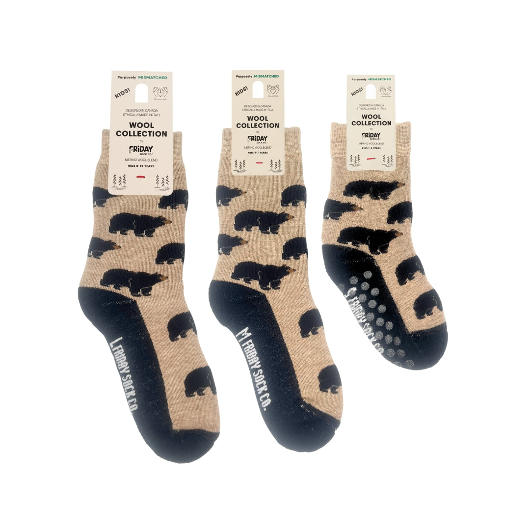 Three pairs of Lumberjack Socks & Co. bear-print socks in the Wool Collection, featuring a tan background with black bear silhouettes and dark navy blue heels, toes, and soles with grip dots.