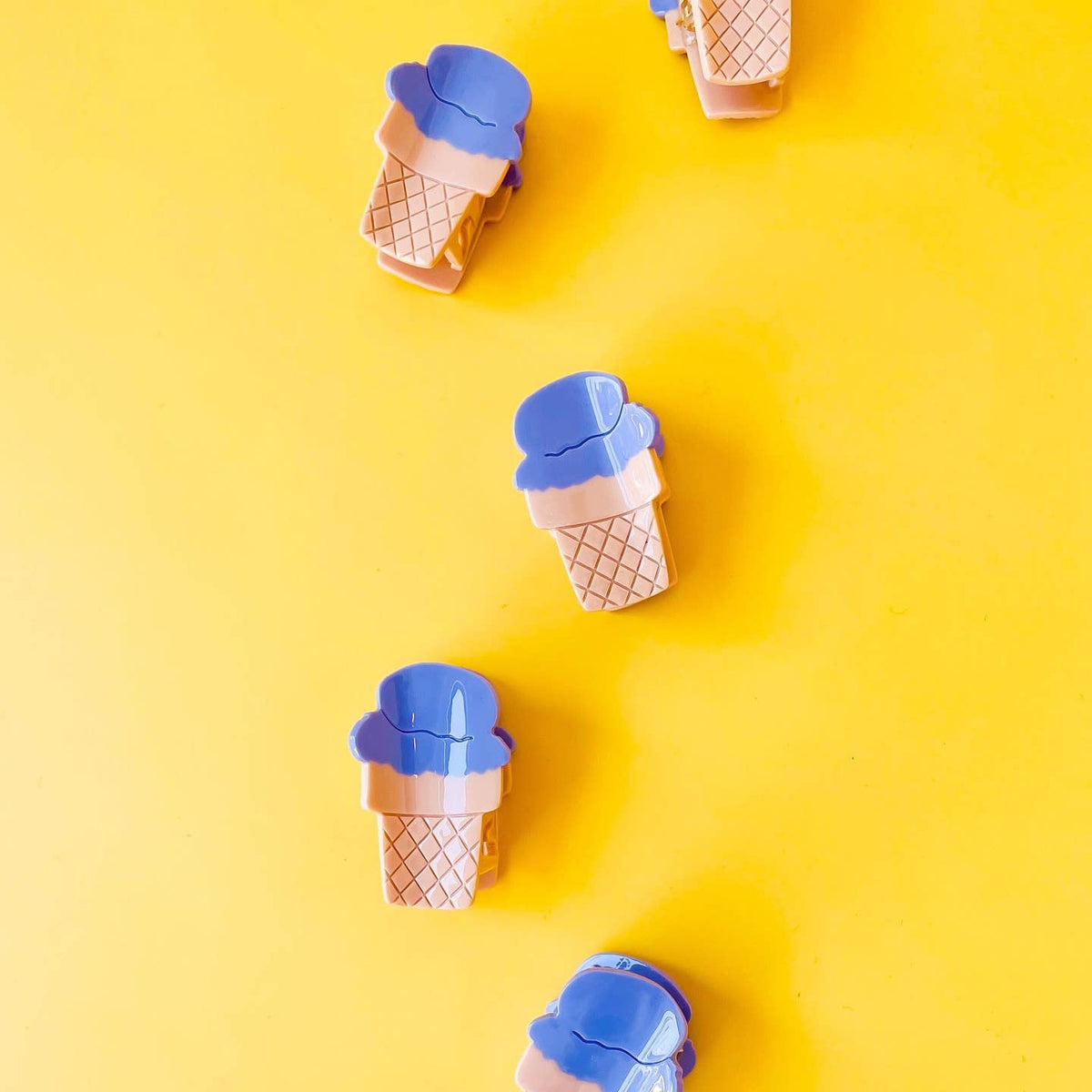 Ice cream cone-shaped objects with blue tops on a yellow background