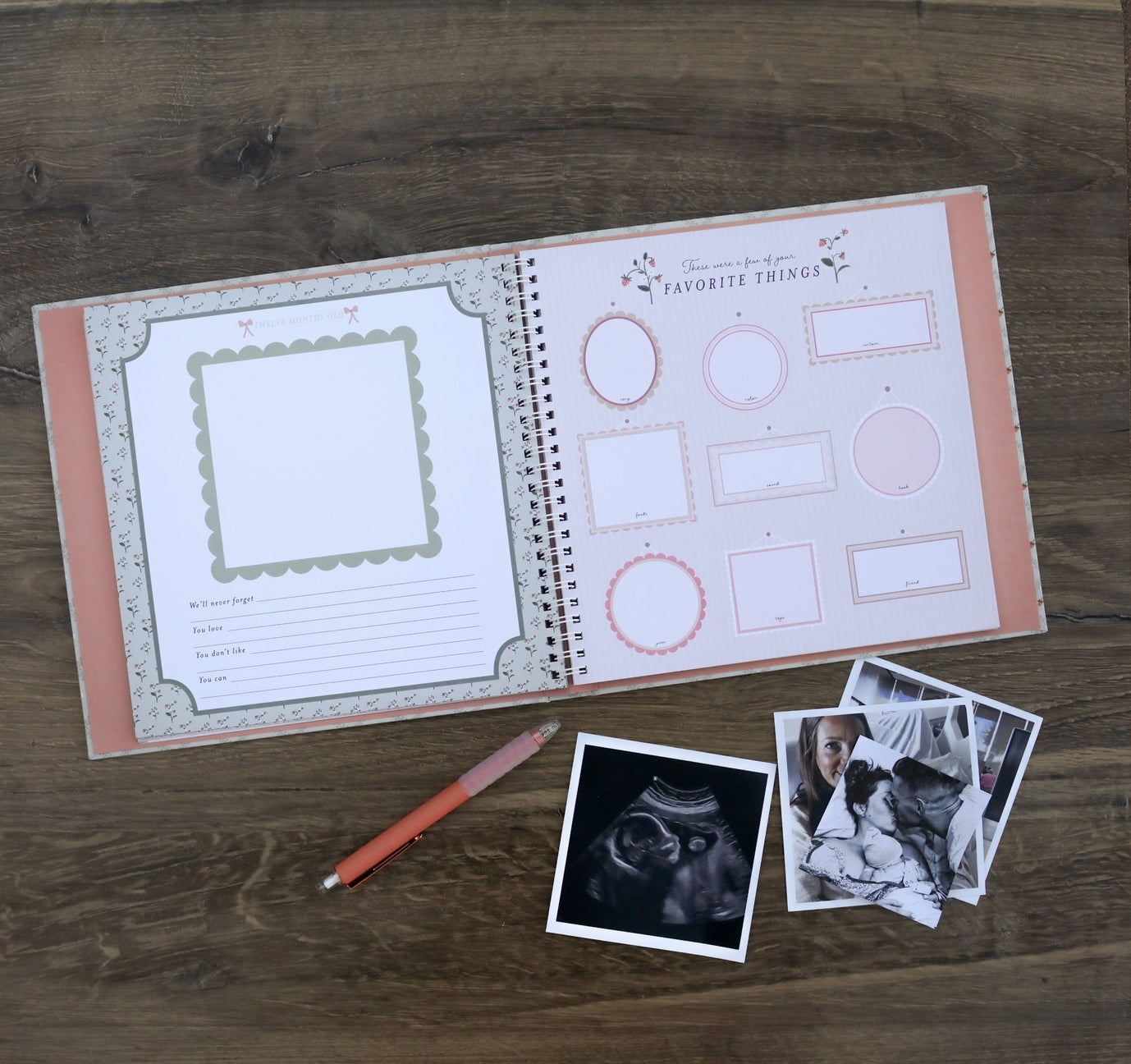 Open book with pre-printed pages on a wooden surface with a pen and photos.