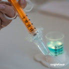 Hand holding a measuring spoon with liquid, blurred background