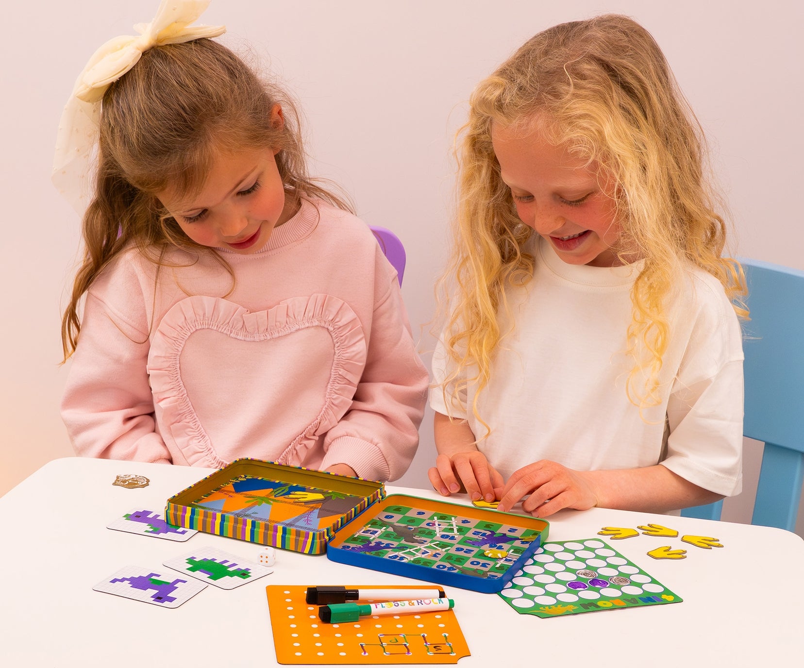 Two young girls playing with educational games at a table.