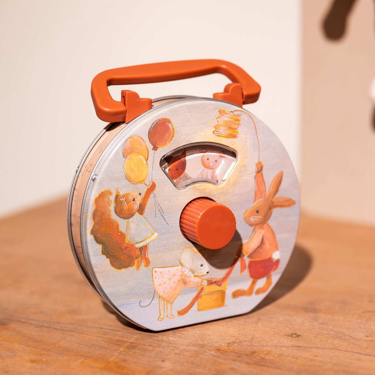 Toy spool with cartoon characters on a wooden surface