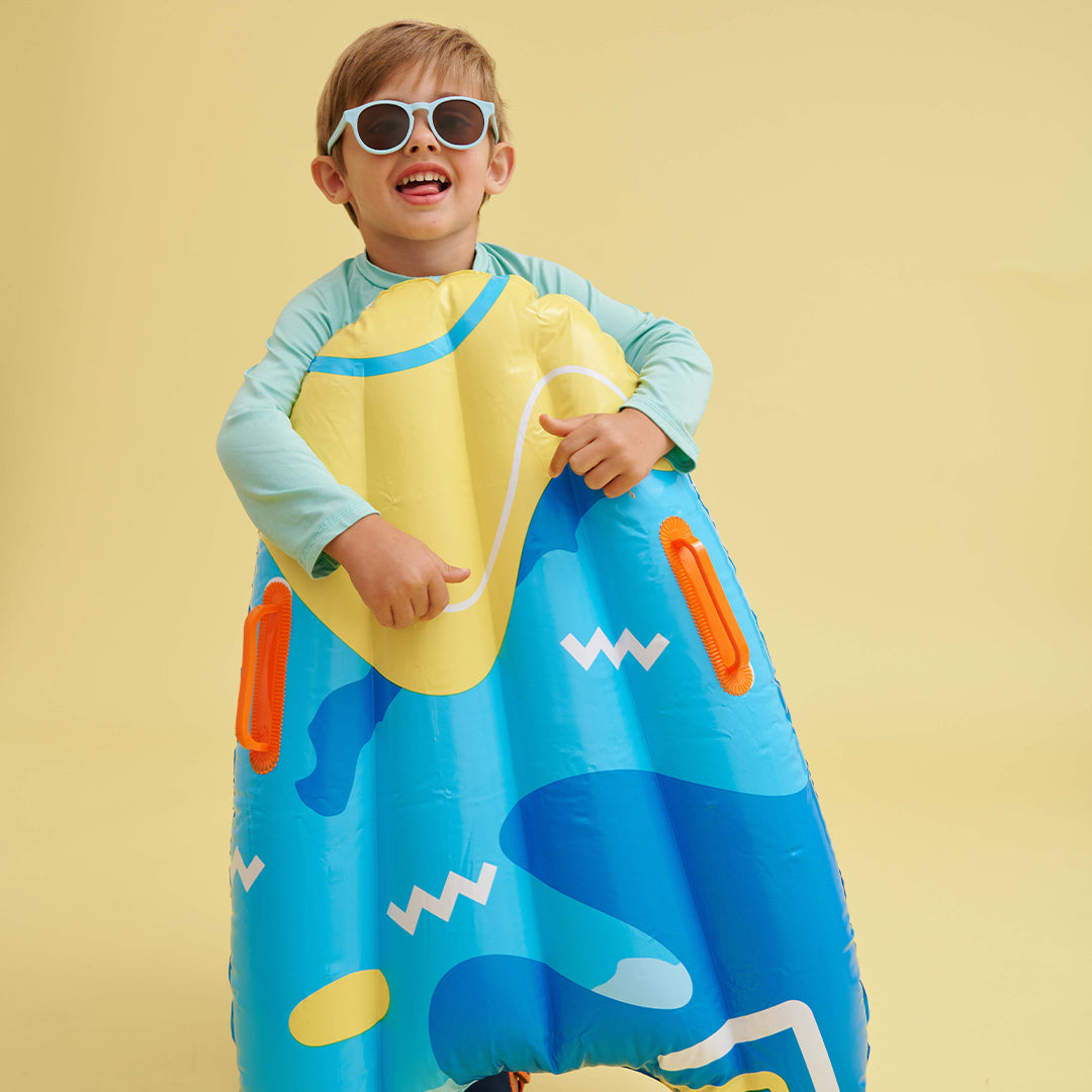 Child wearing a colorful inflatable raft against a yellow background
