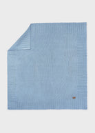 Light blue knitted blanket on a white background