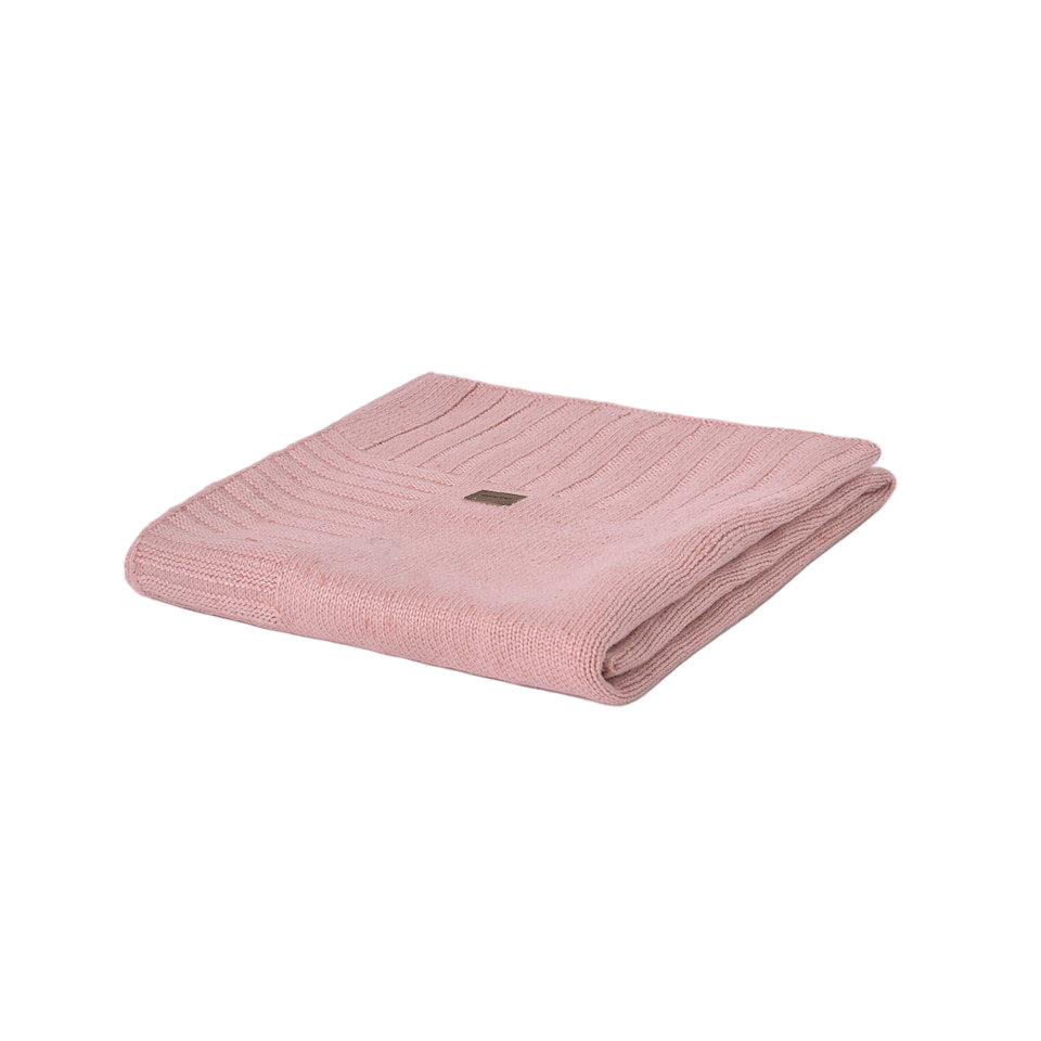 A folded dusty pink ribbed knit blanket with a small brown brand tag, isolated on a white background.