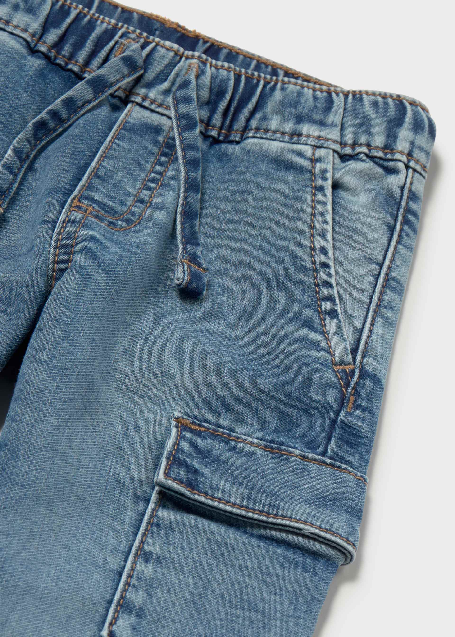 Close-up of blue denim pants with a white background