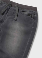 Dark gray pants with a brand label on a light gray background