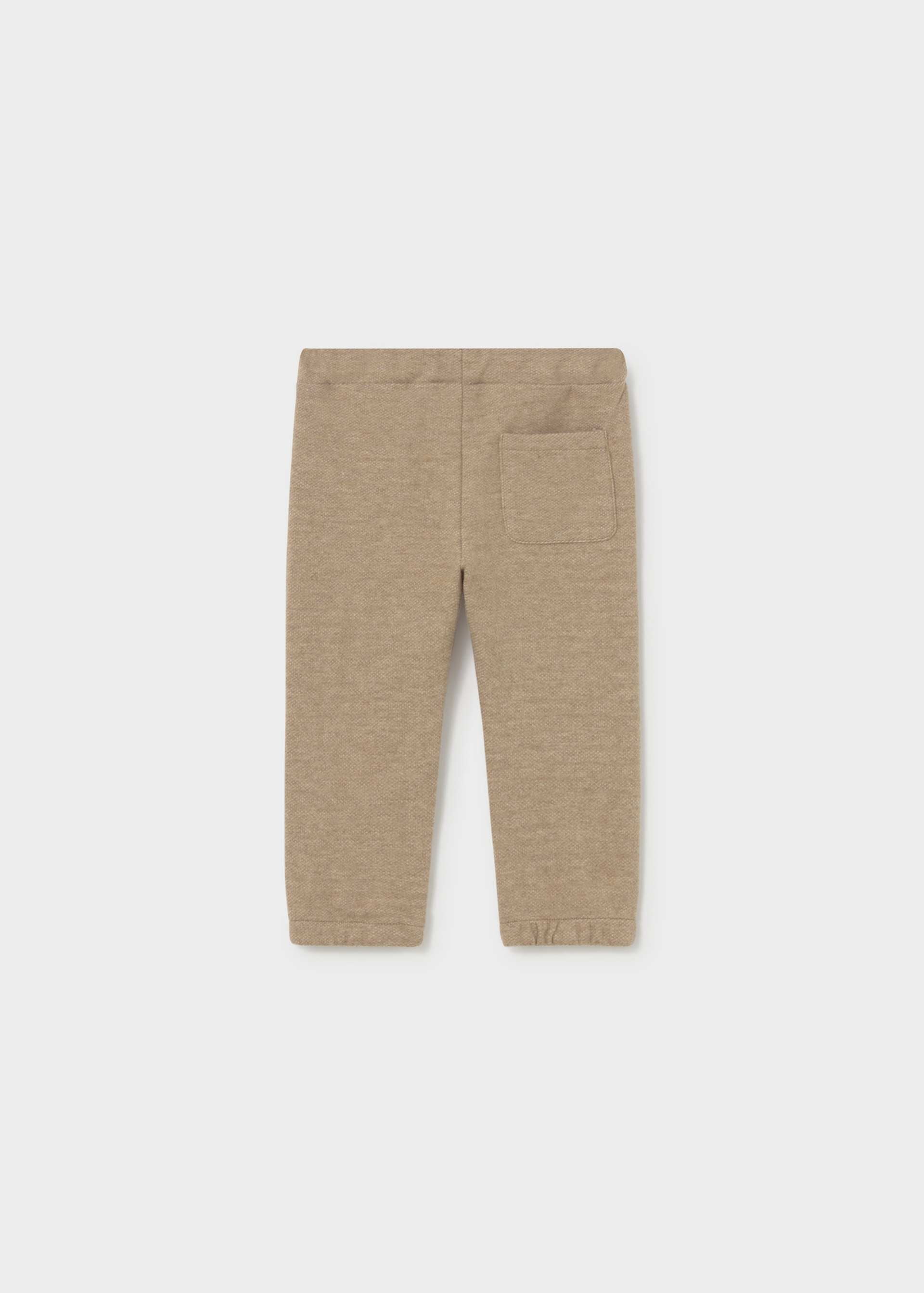 A pair of children's heathered tan pants with an elastic waistband and a side pocket, shown flat against a light gray background.