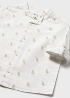 White shirt with small embroidered designs on a white background