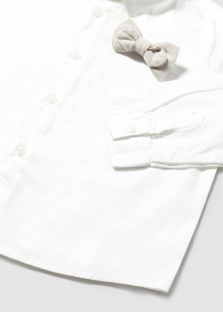 White baby outfit with a bow on a white background