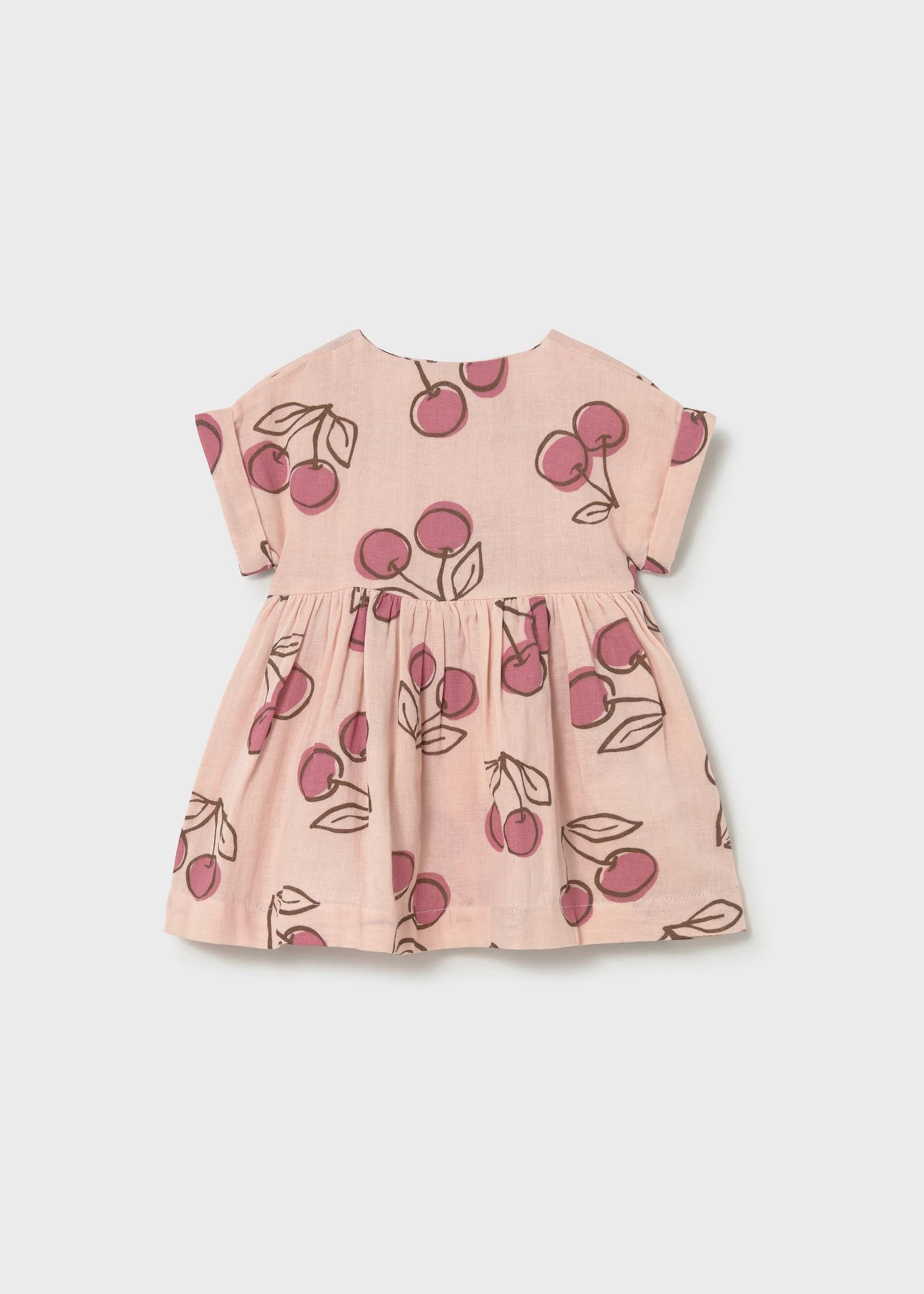 Pink dress with cherry pattern on a light gray background