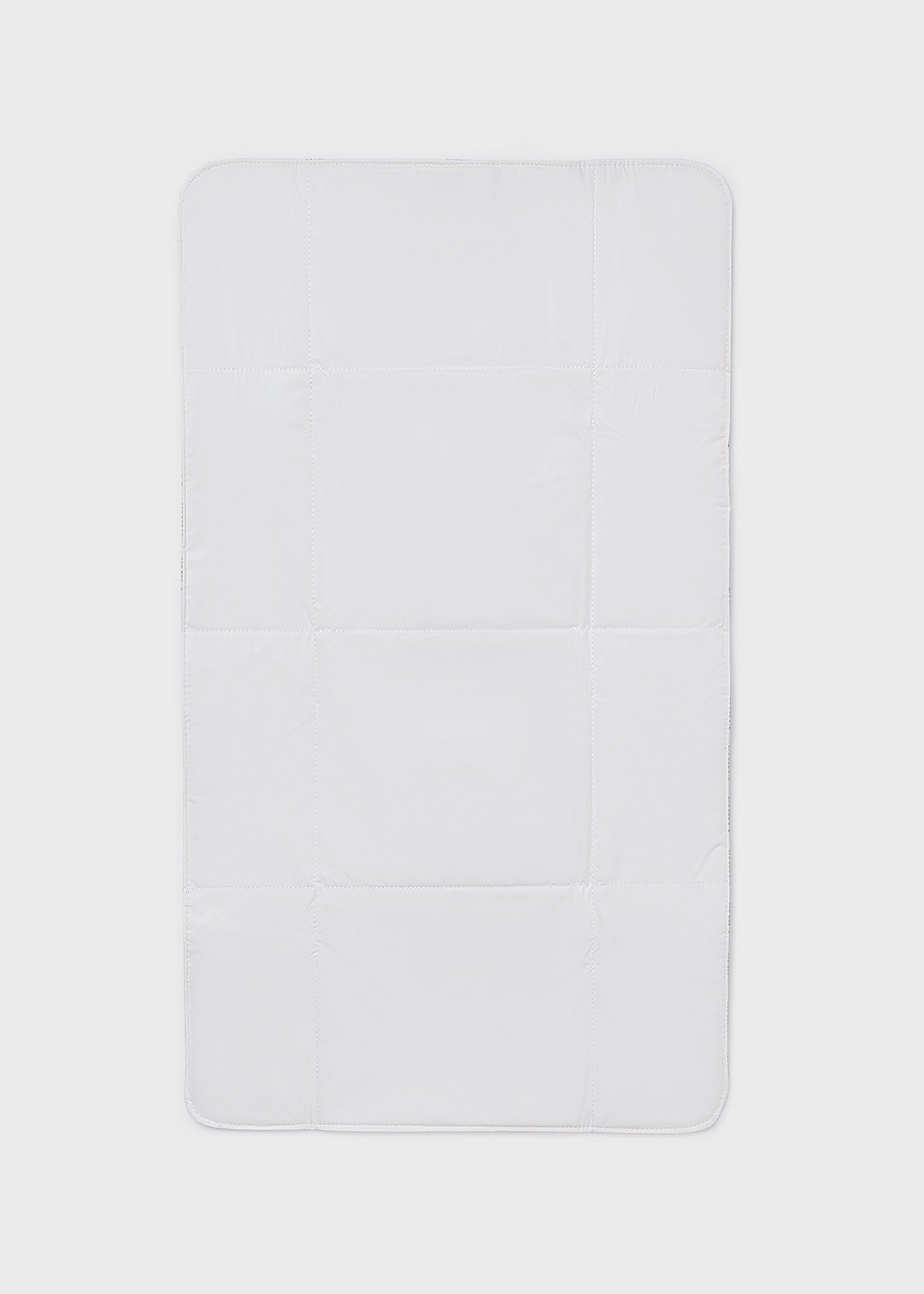 Rectangular white bath mat on a light gray background