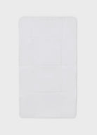 Rectangular white bath mat on a light gray background