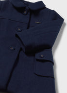 Navy blue coat with button details on a light gray background