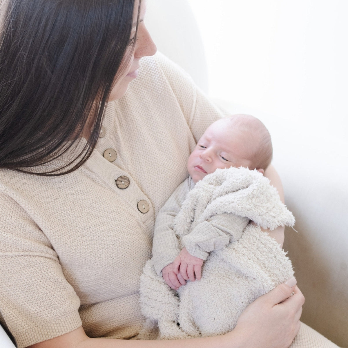 Woman holding a baby wrapped in a soft blanket