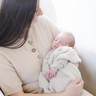 Woman holding a baby wrapped in a soft blanket