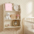 Nursery room with a shelf displaying toys and decor, and a crib in the corner.