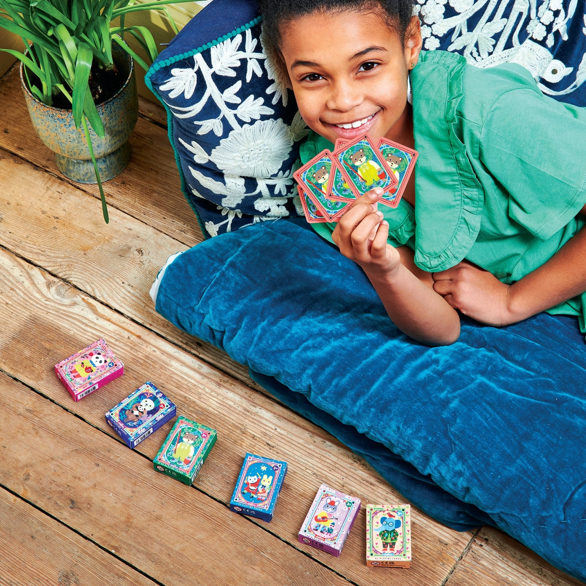 Child playing with colorful cards on a wooden floor