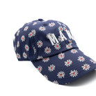 Navy blue cap with white floral pattern and red centers on a white background