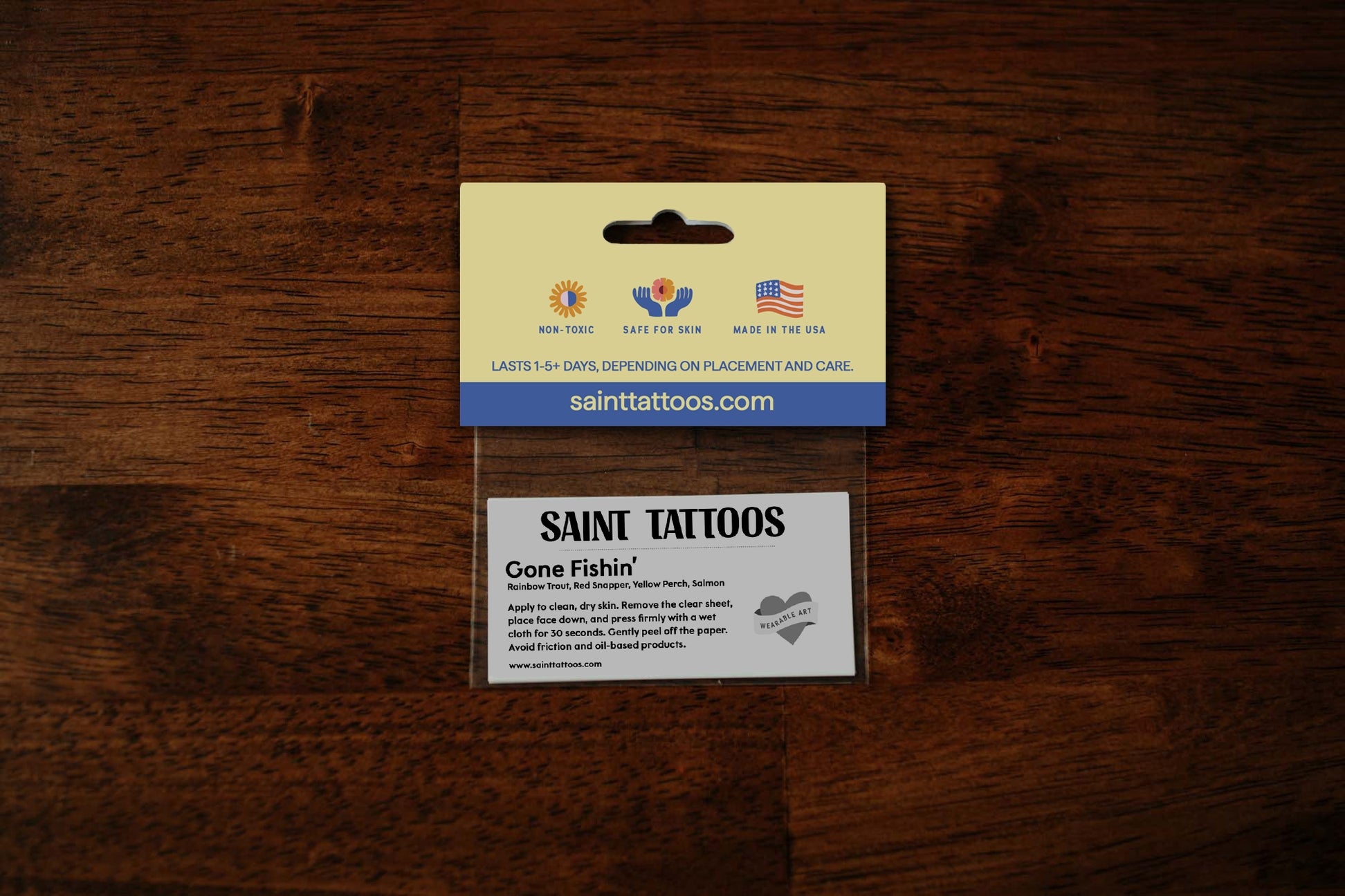 Saint Tattoos packaging on a wooden surface