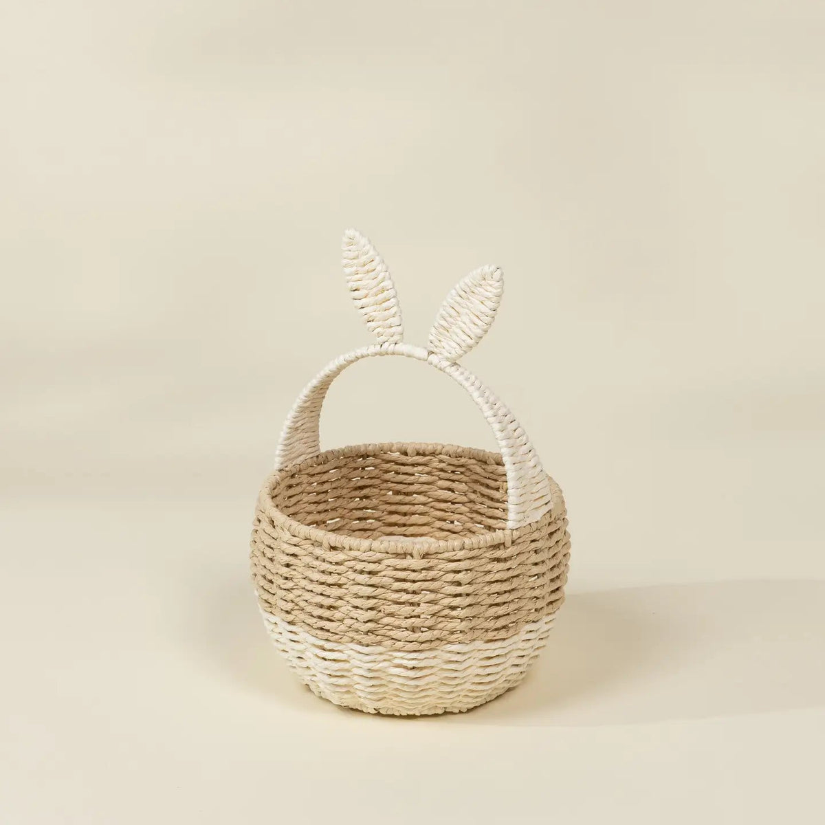 Woven basket with bunny ears on a beige background