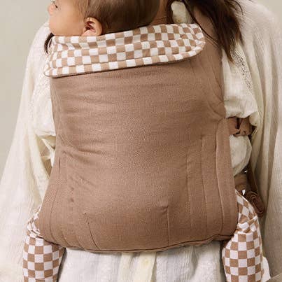 Person wearing a baby in a woven carrier with a checkered hood.