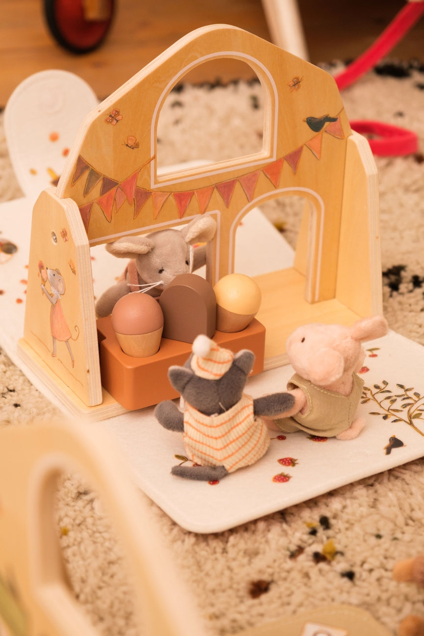Wooden toy set with animal figures on a carpeted floor