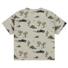 Children's t-shirt with desert-themed pattern featuring cacti and trucks on a beige background