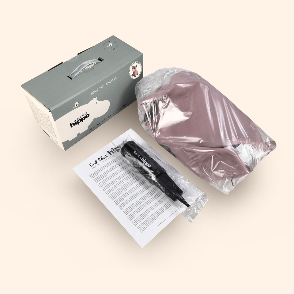 Hippo product packaging with helmet, box, and paper on a beige background