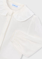 White blouse with a ruffled collar on a light gray background