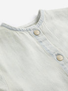 Light blue denim fabric with button details on a white background