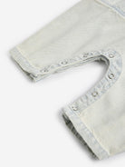 Close-up of light gray denim shorts with frayed edges on a white background