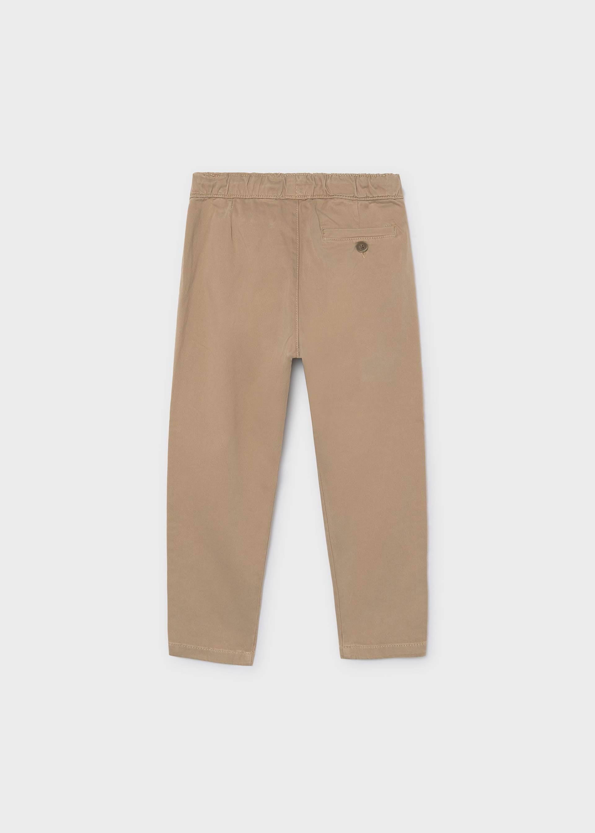 A pair of beige trousers shown from the back on a light gray background.