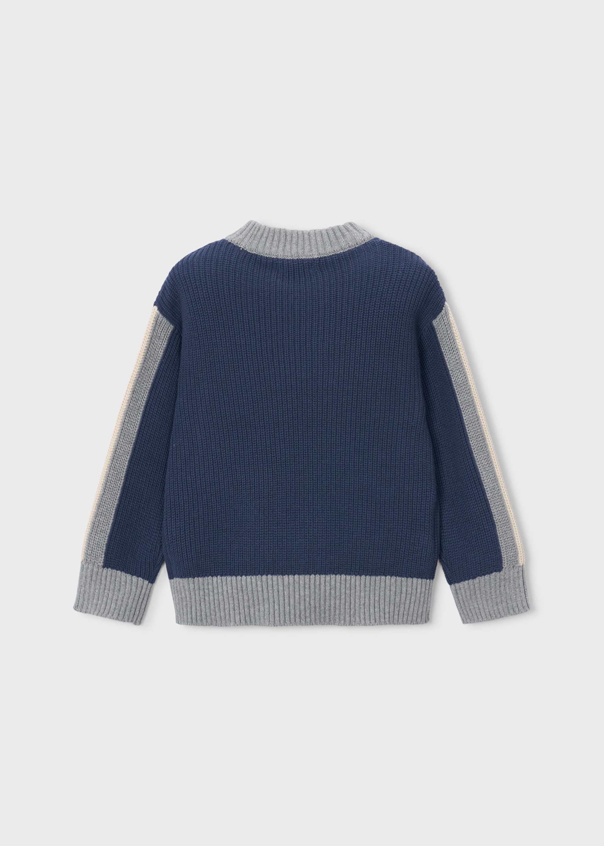 A navy blue ribbed knit sweater with light gray ribbed trim on the collar, cuffs, and hem, featuring light gray and off-white sleeve panels, shown from the back on a light gray background.