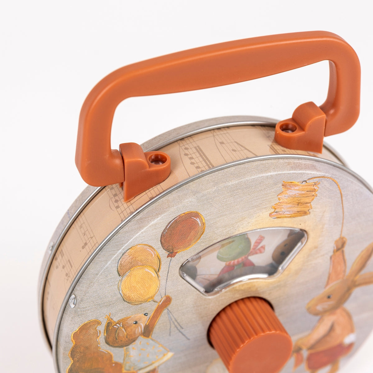 Close-up of a pancake maker with decorative lid featuring illustrations and orange handle.