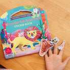 Sticker book with animal illustrations on a wooden surface
