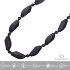 A black beaded necklace with elongated faceted beads and small spacer beads on a thin cord, shown against a plain white background.