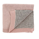 A folded knit blanket with a dusty pink ribbed border and a heathered gray and white woven center, shown on a plain white background.