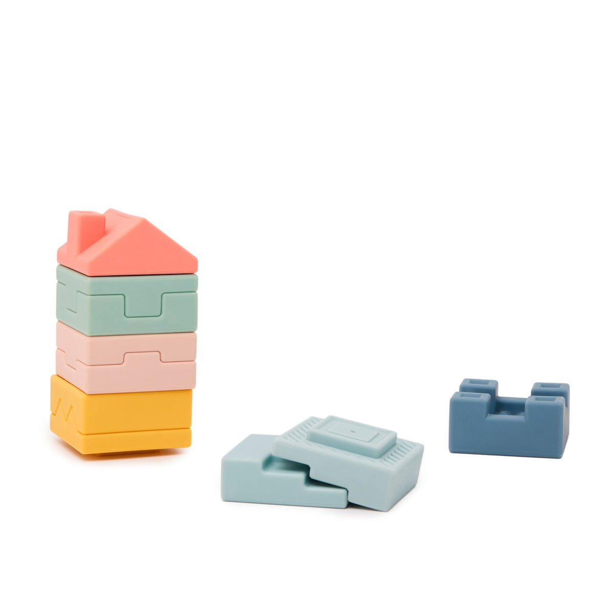 A set of pastel-colored wooden building blocks on a clean white background. The set includes a stack of four house-shaped blocks in coral pink, mint green, pale pink, and yellow, along with two loose blocks in light blue and medium blue.