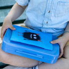 Person holding a blue lunch box with a cartoon character on it.