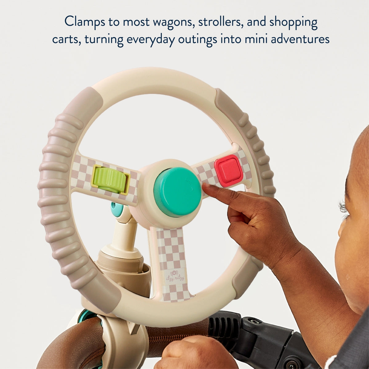 Child's hand interacting with a toy steering wheel attached to a stroller, with text about clamping to wagons and strollers.