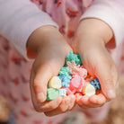 Child's hands holding colorful candy-shaped toys