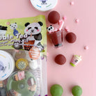Squishy toy set with packaging on a pink background