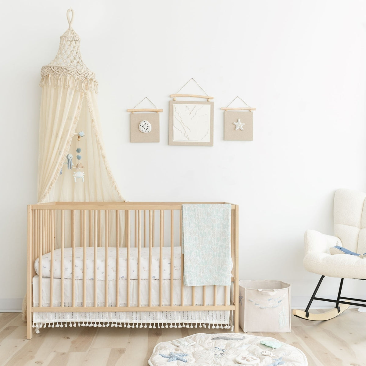 Nursery room with a wooden crib, canopy, and decorative elements.