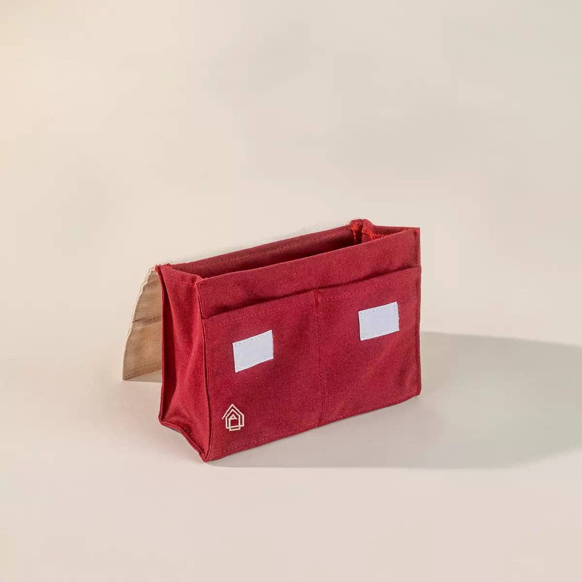 Red and cream fabric bag on a white background.