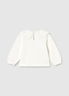 An off-white long-sleeve blouse for a toddler, featuring a decorative ruffled collar with embroidered details and elasticized cuffs, shown flat on a light gray background.