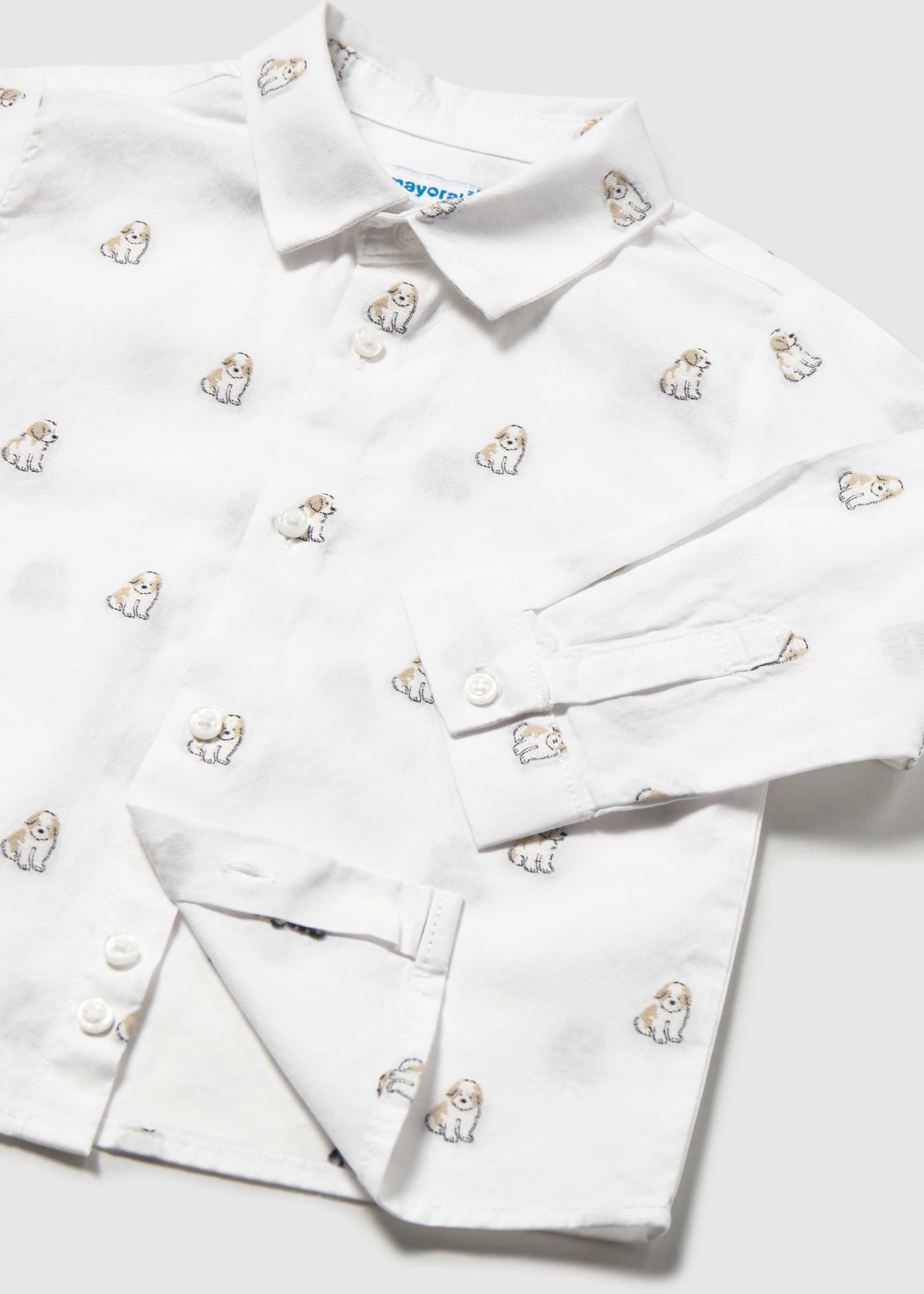 A white long-sleeve button-up shirt with an all-over embroidered pattern of small dogs, shown folded on a light gray background.