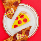 Pizza-themed cookies on a plate with a red background
